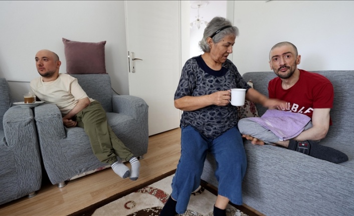Engelli iki oğluna şefkatle bakıyor