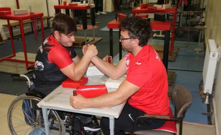 Aynı engele sahip olan öğrencisi ile bilek güreşi yapıyor